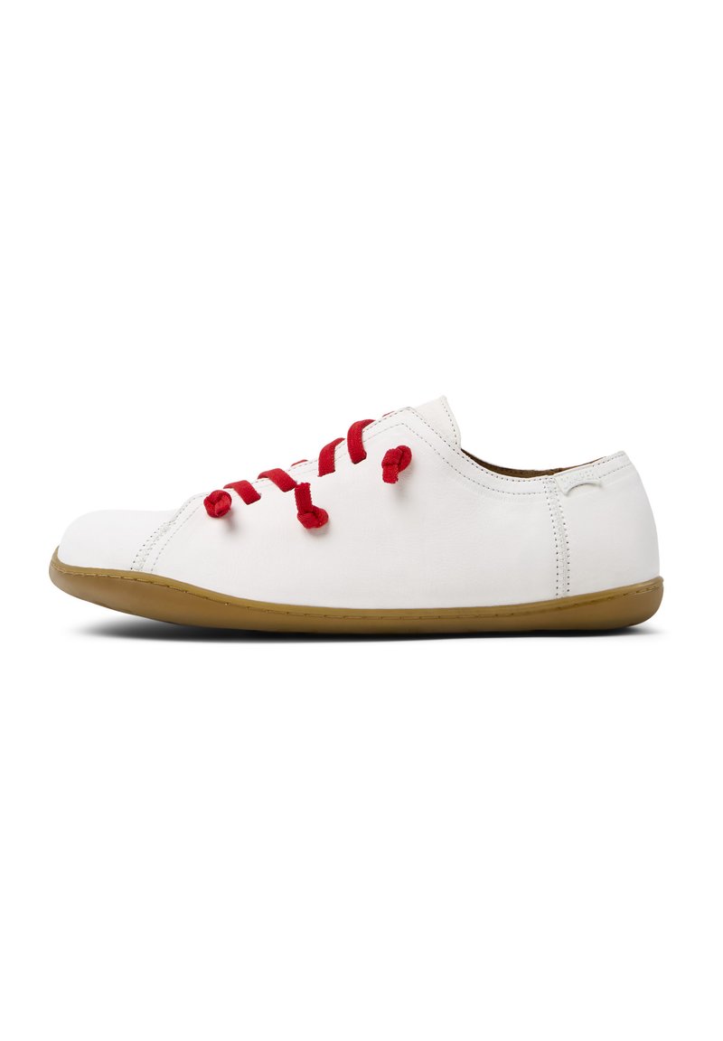 Sneakers bianchi in tela con lacci rossi, punta rotonda, design a taglio basso e suola in gomma naturale. Stile minimalista con accenti cuciti.