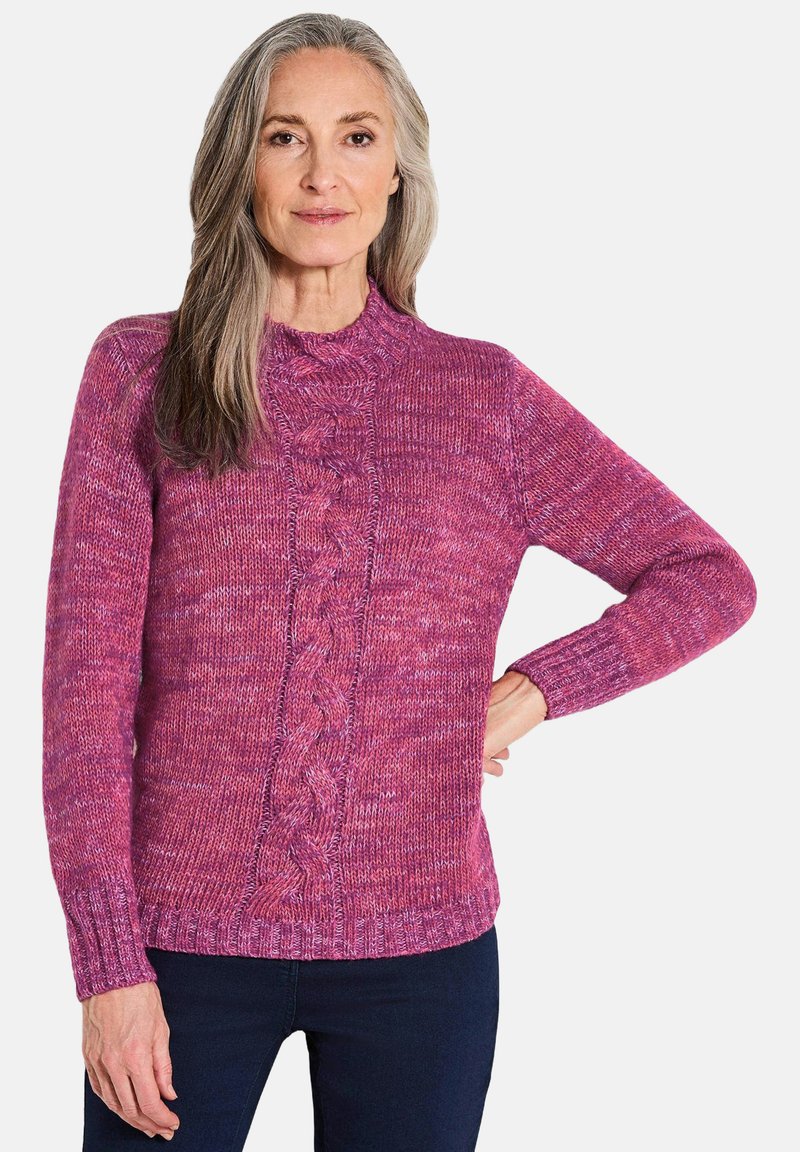 Pull en tricot dans un rose varié avec un motif en torsades au centre. Présente un col montant et des poignets côtelés. Texture douce.