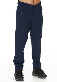Marinblå utomhusbyxor gjorda av softshell-material, med zippered fickor, knäppning med knapp och justerbara muddar för en säker passform.
