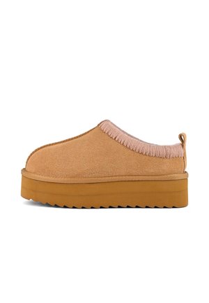Brown suede slide-on shoe with a pink ribbed collar and a thick, textured gum sole. The design features a rounded toe and minimalist style.