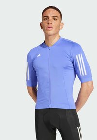 Maglia da ciclismo a maniche corte da uomo di colore azzurro chiaro, realizzata in tessuto testurizzato. Presenta una chiusura a zip frontale e tre strisce bianche sulle maniche.
