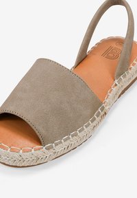 Sandalo espadrille in suede marrone con punta aperta, cinturino elasticizzato al tallone, suola in juta intrecciata beige e soletta in pelle marrone.