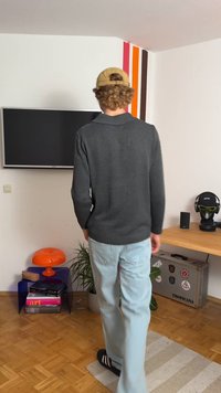 Söešhallane hall kudumüts, millel on ümar kaelus, on paari pandud helesiniste teksade ning mustade libisemis-sandaalidega, omades mugavat lõiget ja soonikku. 