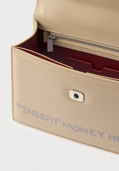 Μπεζ δερμάτινο πορτοφόλι με ασημένιο φερμουάρ, κόκκινο εσωτερικό και ασημένιο κείμενο "ΒΑΛΕ ΧΡΗΜΑΤΑ ΕΔΩ" στην μπροστινή πτυχή.