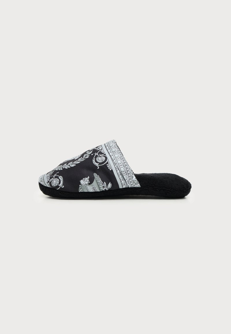Chausson noir à enfiler avec un motif orné gris et blanc sur la tige et une semelle douce et pelucheuse.