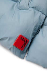 Doudoune bleu clair avec texture matelassée, dotée d'un patch logo en caoutchouc rouge portant l'inscription "MAX&Co." à l'avant. Matériau doux et lisse.