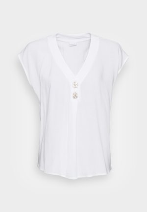 Witte blouse met een V-hals, korte kapmouwen en drie decoratieve knopen aan de voorkant. Gemaakt van een gladde, lichtgewicht stof.