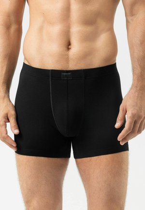 Zwarte badslips gemaakt van zachte, rekbare stof, met een horizontale gulp, smalle tailleband en een lichte glans. Glad oppervlak, aansluitend ontwerp.