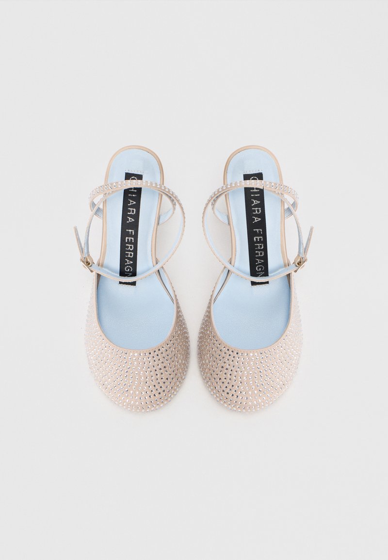Ballerines Mary Jane beige cloutées avec des semelles intérieures bleu clair et des brides de cheville, étiquetées "Chiara Ferragni", sur fond blanc.