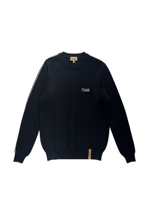 Maglione nero a maniche lunghe con scollo rotondo, strisce bianche sulle maniche, scritta "T CLASSE" sul petto e una piccola etichetta marrone chiaro vicino all'orlo.