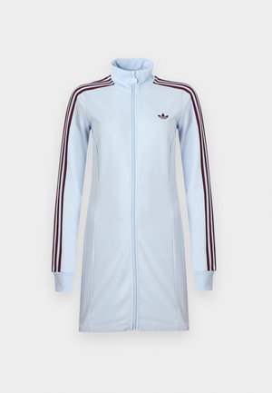 Chaqueta deportiva azul claro con cierre de cremallera y cuello alto, con rayas burdeos en las mangas y un pequeño logo en el pecho. Textura de tela lisa.