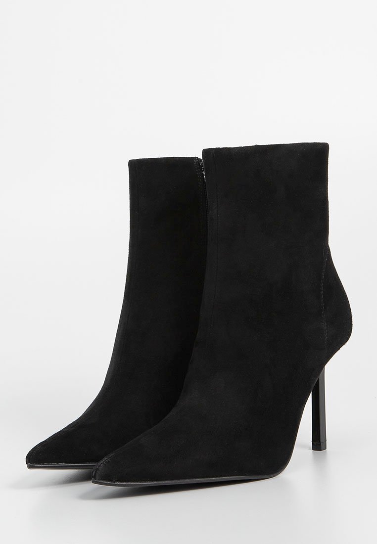 Schwarze Wildleder-Ankle Boots mit spitzem Zeh, hohem Stiletto-Absatz und seitlichem Reißverschluss. Glatte Textur ohne sichtbare Muster.