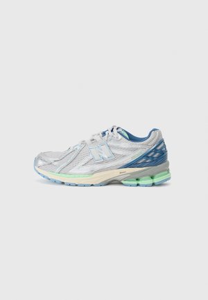 But do biegania z białą siateczkową cholewką, niebieskimi i zielonymi akcentami, wyściełaną podeszwą oraz logo New Balance po boku na neutralnym tle.