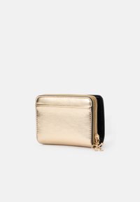 Porte-monnaie métallique doré avec une fermeture éclair, intérieur noir, texture lisse et une fente pour carte de crédit à l'avant. Comprend un charm en or.