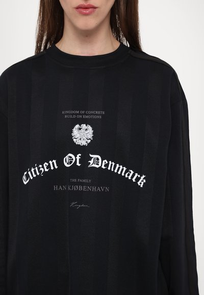 Black long-sleeve sweatshirt featuring a striped pattern, emblem design, and white text, including "Citizen Of Denmark" and branding details.