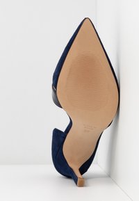 Scarpa con tacco alto in suede blu navy a punta, mostrata dal fondo, con misura 37 e marcatura Made in Spain.