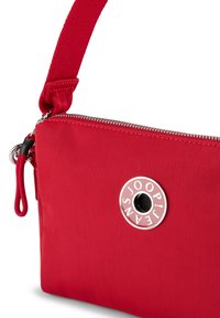 Borsa a spalla rossa in nylon con logo circolare argentato, chiusura a zip e tracolla regolabile. Presenta una superficie testurizzata e un design elegante.