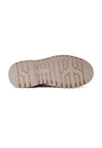 Suela de zapato de goma beige con una superficie texturizada, que presenta surcos y crestas profundas para mayor tracción, punta redondeada y tacón plano.