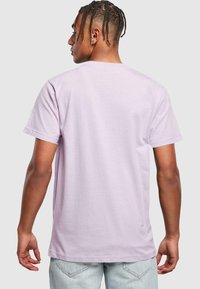 Lys lilla bomulds T-shirt med korte ærmer og rund hals. Enkel design, ensfarvet og afslappet pasform. Synlige syninger.