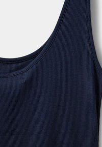 Top din bumbac de culoare bleu marin, cu model cu nervuri, având decolteu rotund și bretele subțiri, realizat dintr-un material moale și elastic, cu o textură vizibilă.