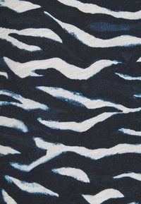 Schwarzer Stoff mit unregelmäßigen weißen und hellblauen wellenförmigen Streifen, die einem abstrakten Tiger- oder Zebra-Muster ähneln.