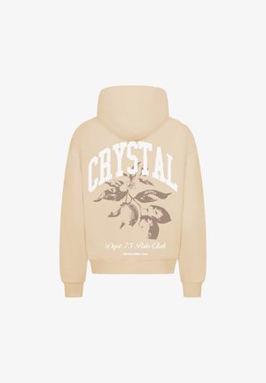 Beżowa bluza z kapturem z dużym nadrukiem "CRYSTAL" oraz botaniczną grafiką z liśćmi i cytrynami na plecach. Posiada ściągacze przy mankietach i u dołu.