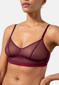 Burgundy läpinäkyvä bralette säädettävillä olkaimilla, joka on varustettu verkkosuunnittelulla, kontrastivärillä, ja pehmeällä, sileällä pinnalla.