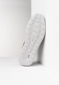 Suola bianca in gomma di una sneaker, caratterizzata da un motivo di battistrada testurizzato e un dettaglio di branding italiano. Il design include scanalature sottili per una presa migliore.