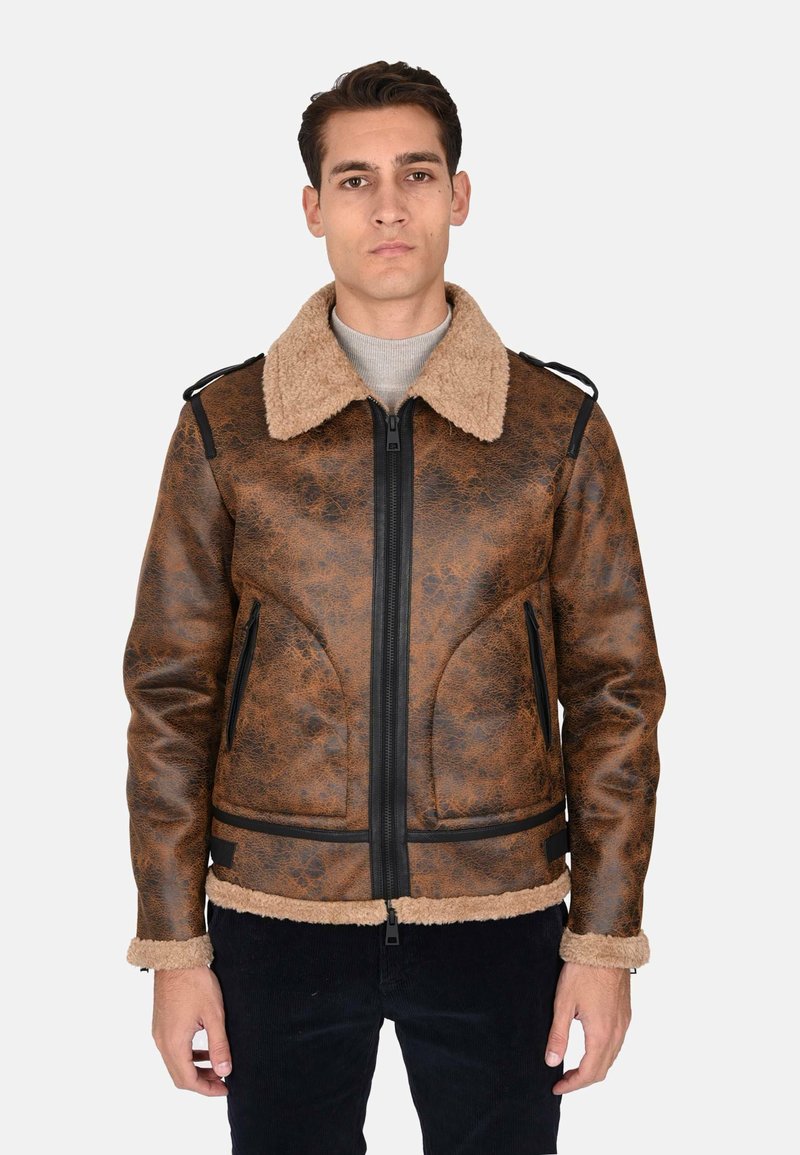 Giubbotto in similpelle marrone con colletto in shearling, chiusura con zip e dettagli neri. Presenta due tasche laterali e una finitura testurizzata.