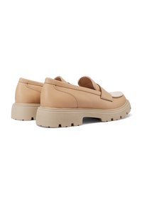 Scarpe slip-on in pelle marrone chiaro con suola in gomma beige piatta. Caratterizzate da cuciture minime e da una finitura liscia. Il design enfatizza il comfort.