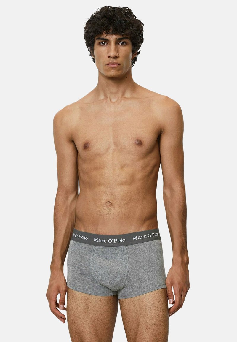 Gli boxer grigi in cotone presentano un colore uniforme, una vita elastica con il nome del marchio. I pantaloni hanno un design aderente e una consistenza liscia.