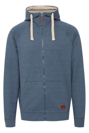 Innvendig hettegenser med glidelås i mørkeblått, laget av myk stoff, med beige snor, frontlommer og et lite brunt logo-patch.