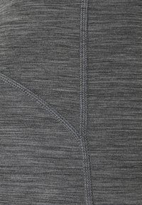 Leggings sportive grigi con un tessuto testurizzato, caratterizzati da cuciture a contrasto e un design aderente. Il dettaglio delle cuciture visibili migliora la struttura.