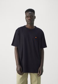 Schwarzes Baumwoll-T-Shirt mit kurzen Ärmeln, Rundhalsausschnitt und kleinem gesticktem Logo in Rot und Gelb. Lockere Passform, glatte Textur.