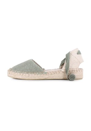 Espadrilles tejidas de color verde claro con suela de yute, que cuentan con punta afilada y un lazo en el tobillo de textura, adornado con un acento enrollado.