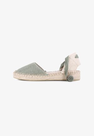 Espadrilles tejidas de color verde claro con suela de yute, que cuentan con punta afilada y un lazo en el tobillo de textura, adornado con un acento enrollado.