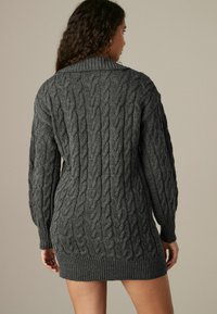 Robe pull en maille torsadée gris foncé, avec un col large, des manches longues et un ourlet côtelé, dotée d'un motif texturé tout au long.