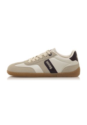Zapatilla beige y blanca con parte superior de ante y cuero, que presenta una suela de goma marrón, cordones crema y un logo en contraste en el lateral.