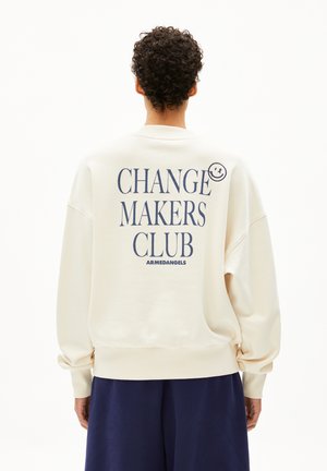 Crème kleurige sweatshirt met een oversized pasvorm, voorzien van navy blauwe tekst "CHANGE MAKERS CLUB" en een klein smiley-logo nabij de schouder.