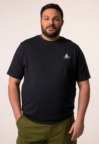 Černé tričko s krátkým rukávem, měkká látka, kulatý výstřih, na levé straně hrudi se nachází bílé logo plachetnice, stylizováno s zelenými cargo šortkami.