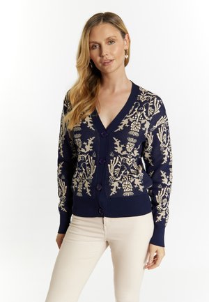 Marineblauer Cardigan mit beigem Blumenmuster, V-Ausschnitt, langen Ärmeln und Knöpfen vorne. Gerippter Saum und Bündchen.