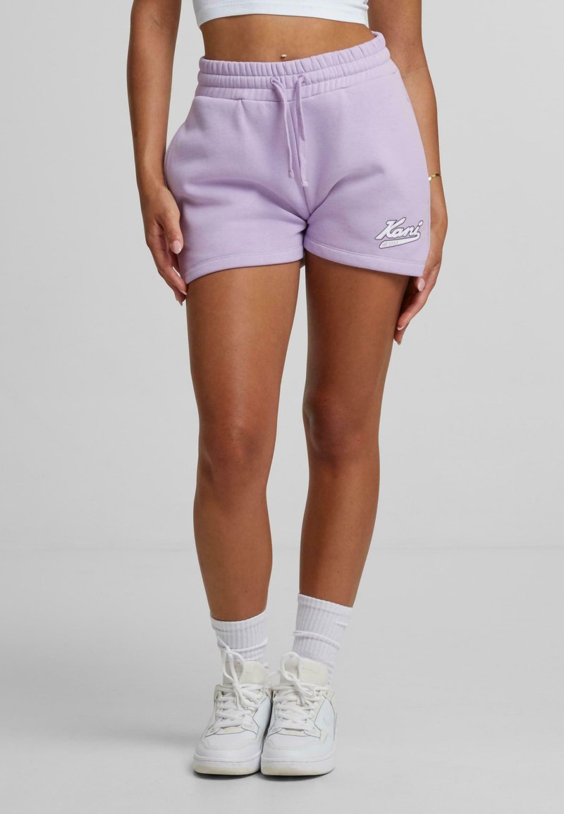 Lila bomullsshorts med elastisk midja och dragsko, med en vit logotyp på vänster fåll och en avslappnad passform.