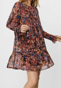 Květinové vzorované, průhledné šaty s dlouhými rukávy, nařaseným výstřihem a volánkovým lemem; dominantními barvami jsou červená, černá a modrá.