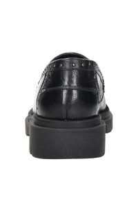 Zwarte leren schoenen met een gestructureerde afwerking, dikke rubberen zool en studs op de bovenkant. De achterkant benadrukt de vorm en materialen.
