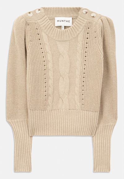 Beige knitted sweater with cable knit design, ribbed hem and cuffs, featuring button details on the shoulder. Textured fabric.