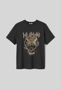 T-shirt en coton noir avec un design graphique d'un tigre rugissant, accompagné du texte "Def Leppard Hysteria Tour 1987" en lettrage stylisé.
