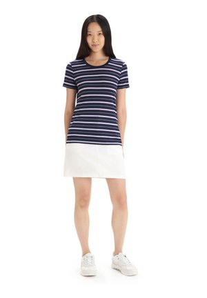 Marineblå og hvide stribede kortærmede top med rund halsudskæring, parret med en hvid miniskørt. Båret med hvide sneakers.