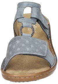 Jasnoniebieskie sandały z perforowaną skórzaną cholewką, regulowanym paskiem i okrąłym metalowym akcentem. Miękka zamszowa wkładka na beżowej gumowej podeszwie.