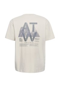 Koszulka z bawełny w kolorze kremowym, zdobiona graficznym wzorem przedstawiającym kształty gór oraz tekst w odcieniach niebieskiego. Krótkie rękawy i luźny fason.