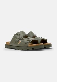 Green rubber sandals with wide straps, featuring buckle accents and a textured sole, displaying a smooth finish and a neutral tan base.